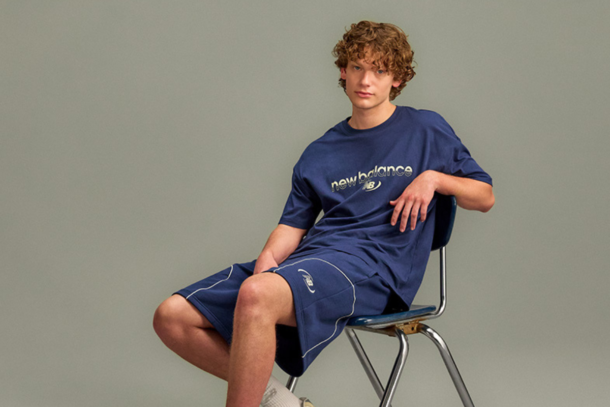 The person is wearing a light gray athletic T-shirt with blue text partially visible reading &ldquo;We&rsquo;re In It For The Long Run.&rdquo; 